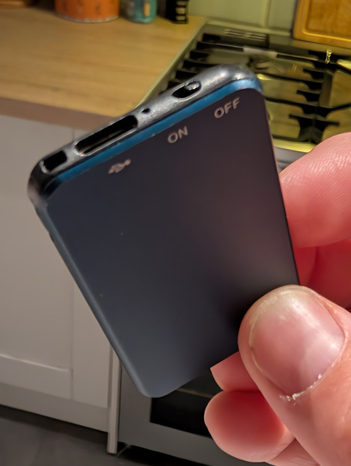 A generic USB voice recorder held in a hand